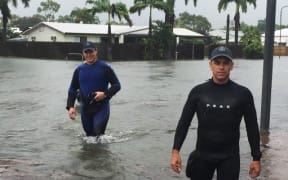 A handout picture provided by Queensland Police Service, taken on February 2, 2019 and release on February 3 shows two police officers wading in flood waters in Townsville. -