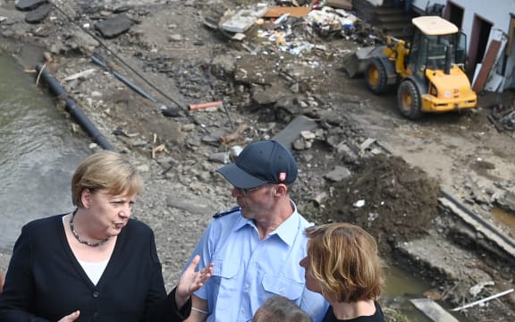 German Chancellor Angela Merkel, left, and Malu Dreyer, right, Prime Minister of Rhineland-Palatinate, stand on a bridge overlooking the flood-ravaged village of Schuld near Bad Neuenahr-Ahrweiler.