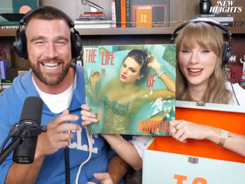 A smiling man and woman hold an album cover.