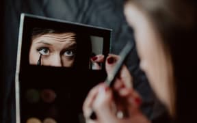 Woman applying liquid black eyeliner. mirror, make up