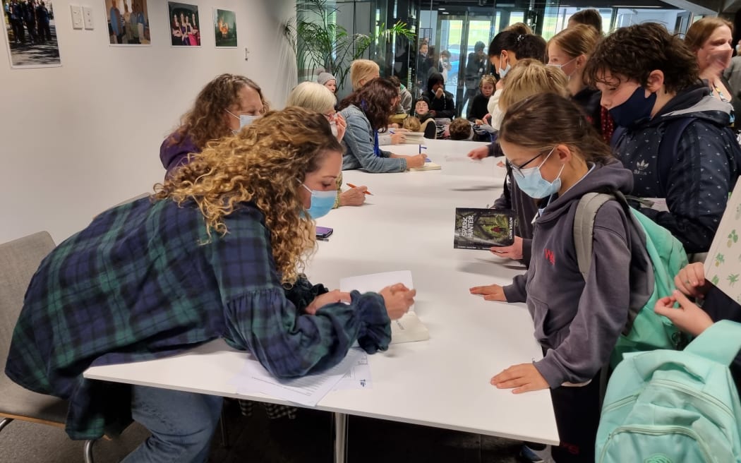 Sonya Wilson signs her book, Spark Hunter, for a student.