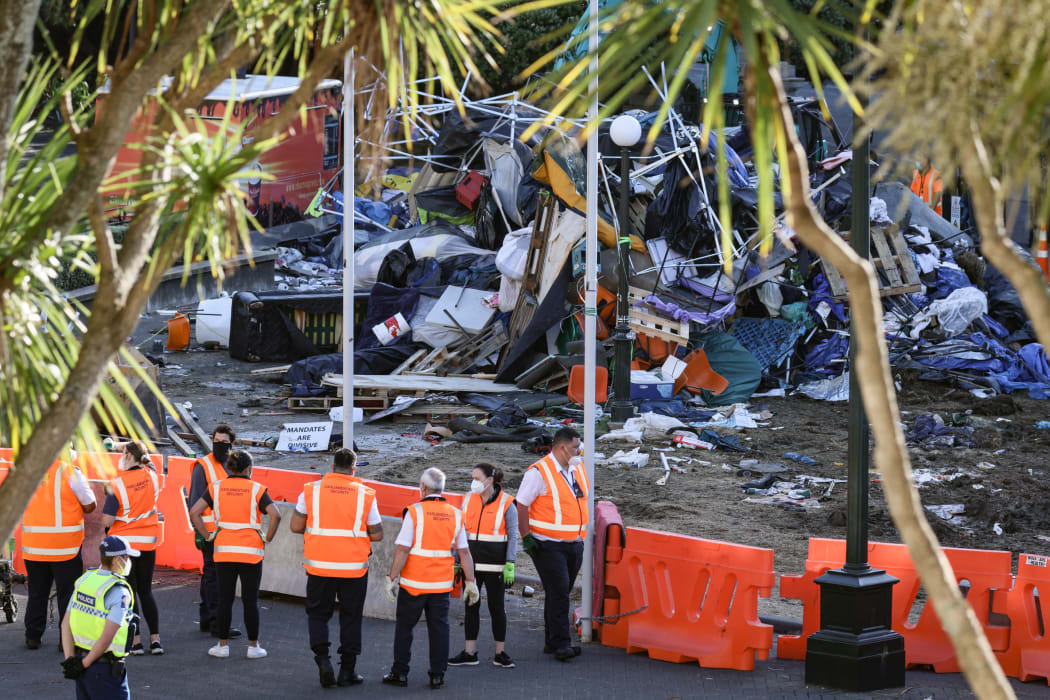 Some of Parliament's security team watch work to remove the rubbish dump on Parliament's lawn