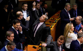 Britain's Brexit Party leader Nigel Farage holds up a small Union Jack in the European Parliament following a vote to ratify the  Brexit deal