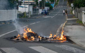 A photo show a fire in the street after a supermarket was looted and shops vandalised in the N'Gea district of Noumea, on May 14, 2024.