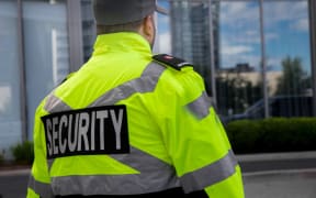 A security guard in uniform patrolling a residential area.