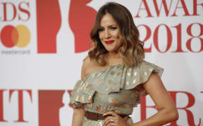 British television presenter Caroline Flack poses on the red carpet on arrival for the BRIT Awards 2018 in London.