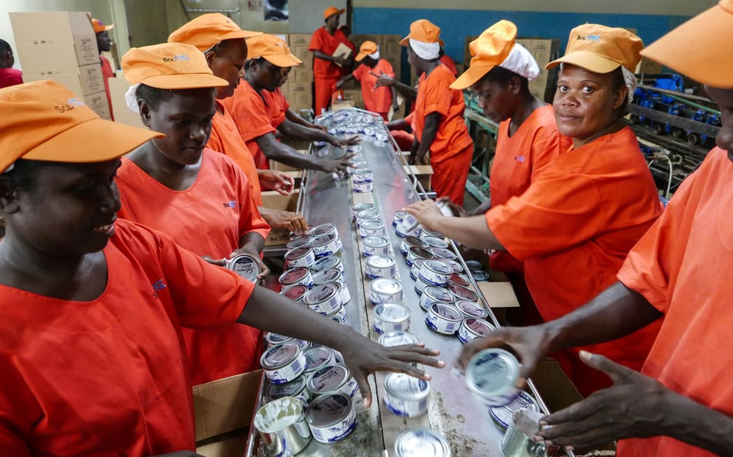 Labelling and packing of locally produced Soltuna cans in Noro, Solomon Islands.