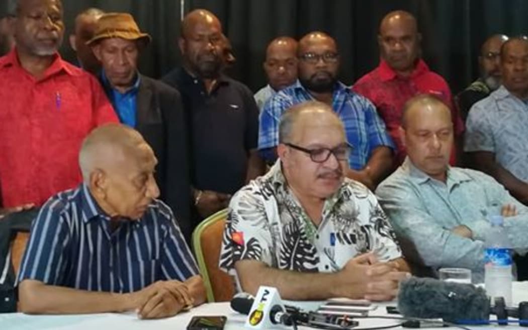 Papua New Guinea Prime Minister Peter O'Neill (seated, centre) announces his resignation, handing over to Sir Julius Chan (seated, left) 27 May 2019