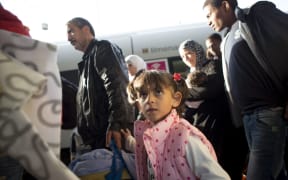 Refugees walk on a Berlin railway platform platform after getting out of a special train coming from Munich.