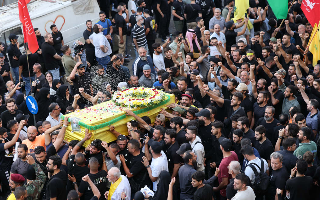 Mourners toss rice over the coffin of a person a killed after hundreds of paging devices exploded in a deadly wave across Lebanon the previous day, during a funeral procession in Beirut's southern suburbs on September 18, 2024. Hundreds of pagers used by Hezbollah members exploded across Lebanon on September 17, killing at least nine people and wounding around 2,800 in blasts the Iran-backed militant group blamed on Israel. (Photo by ANWAR AMRO / AFP)