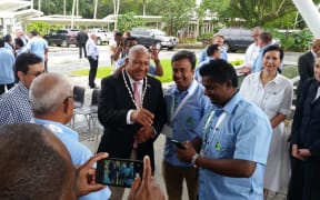 The Fiji Prime Minister Frank Bainimarama meets local & international business people in Fiji at the Fiji/Australia Business council Forum while Australian dignitaries look on.