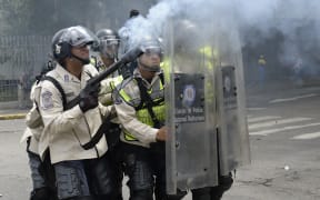 Policemen clash with demonstrators protesting against new emergency powers decreed this week by President Nicolas Maduro in Caracas on May 18, 2016.