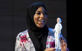 US Olympic Medalist Ibtihaj Muhammad holds the first hijab-wearing Barbie doll.