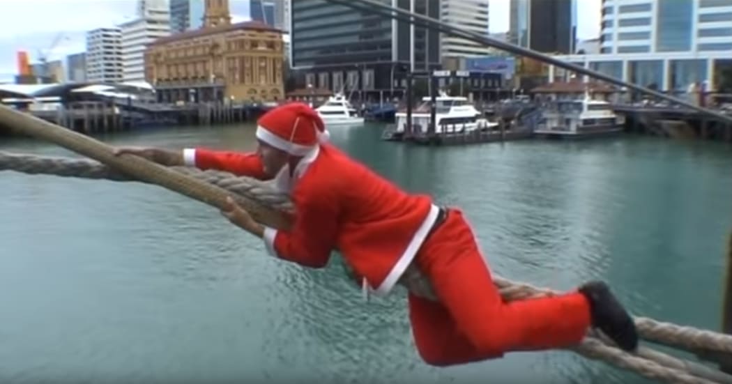 A side on view of the Santa starting his climb up the mooring rope.