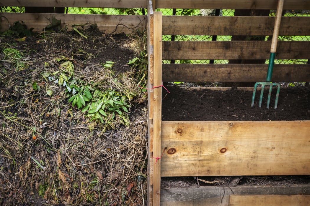 Compost boxes with composted soil and garden waste for backyard composting
