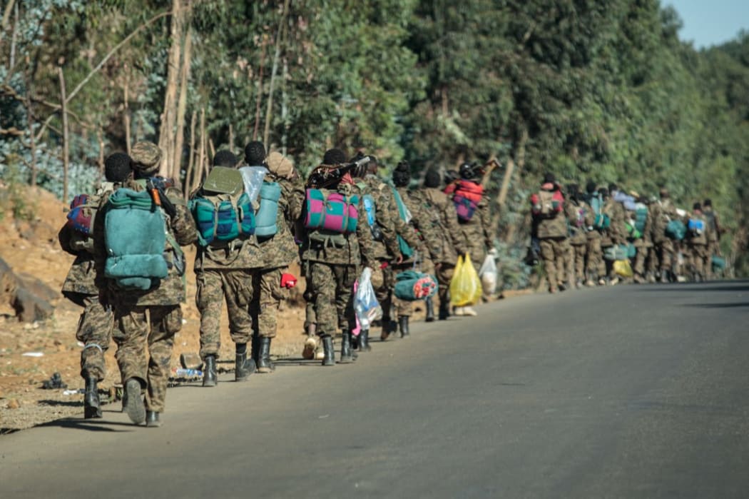 Soldiers of the Ethiopian National Defense Force (ENDF) walk along a road toward the frontline in Gashena.