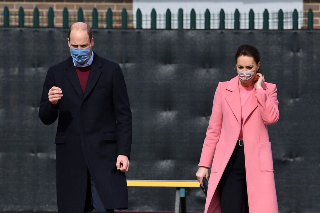 Britain's Prince William, Duke of Cambridge  and Britain's Catherine, Duchess of Cambridge gesture during a visit to School21 following its re-opening after the easing of coronavirus lockdown restrictions in east London on March 11, 2021.