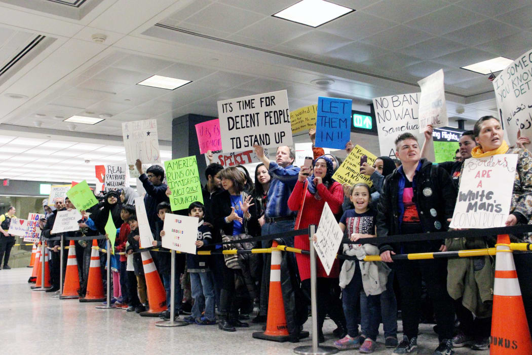 Protesters gather at the international arrivals area of the Washington Dulles International Airport on January 29, 2017, in Sterling, Virginia.