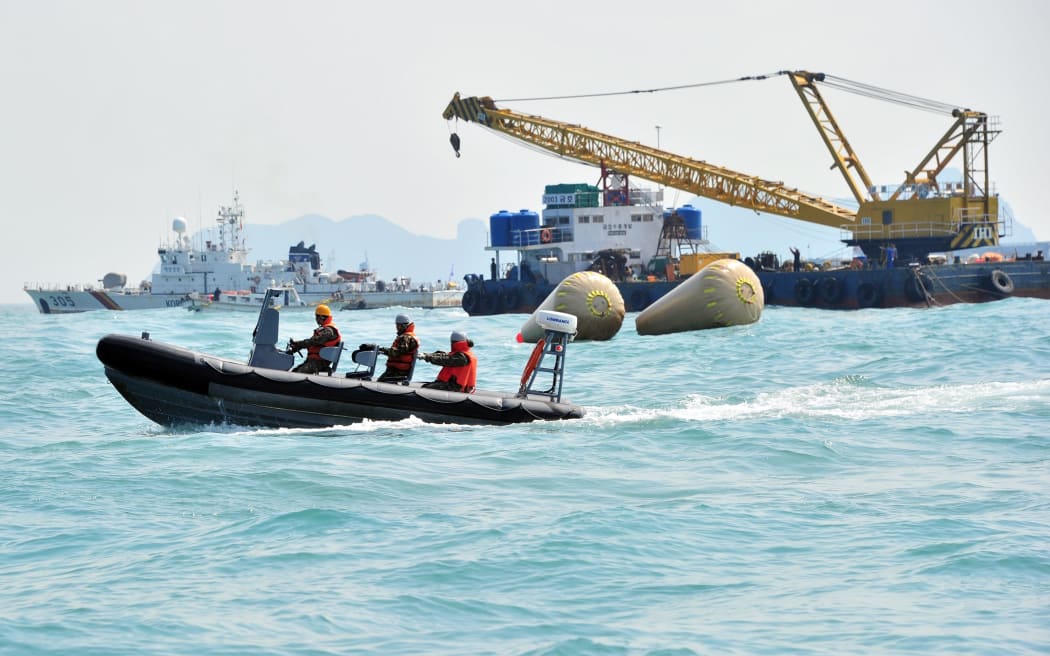 Rescuers search near buoys marking the site of the sinking.