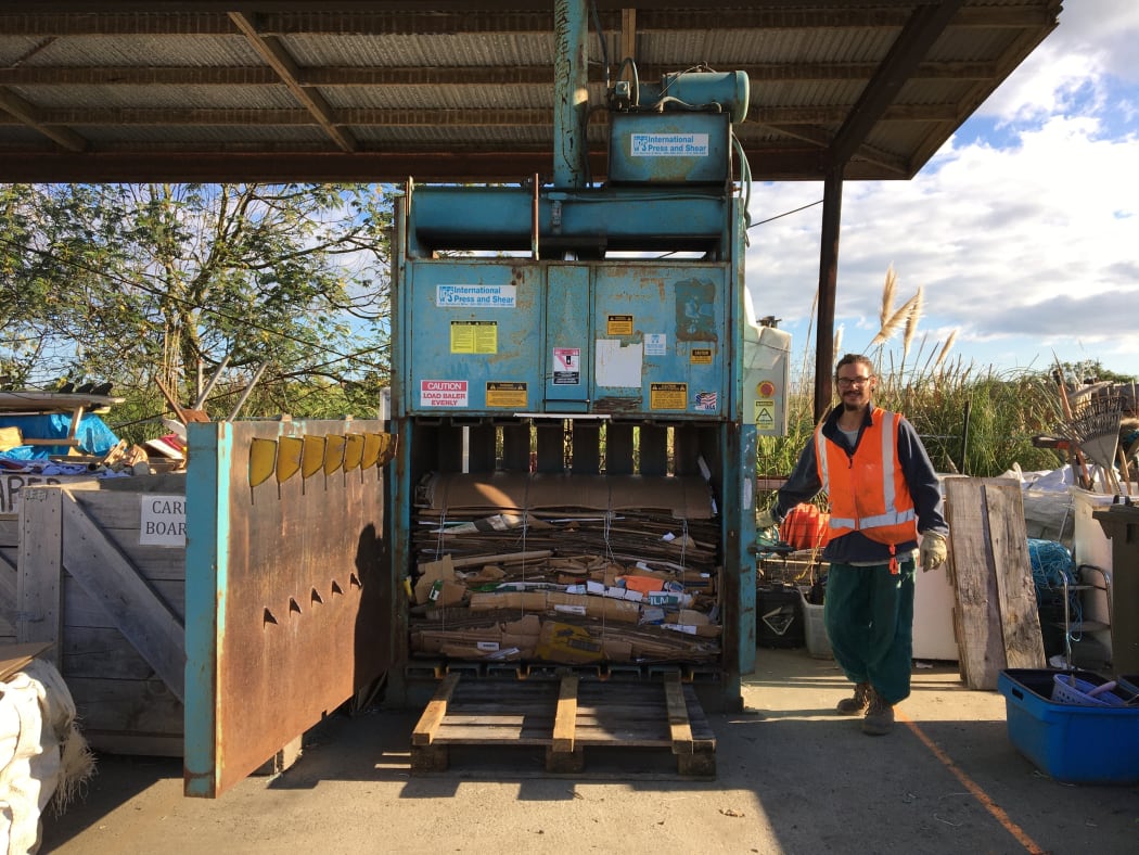 Giosuè Bima, one of the volunteers at the recycling centre standing next to the high density baler machine.