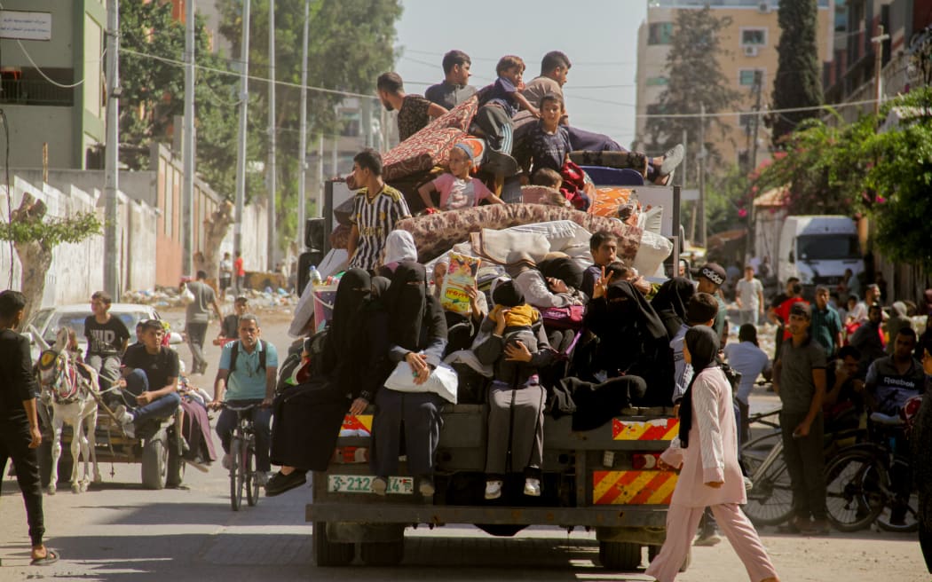 Palestinians carry their belongings as they flee areas north of Gaza City in the northern Gaza Strip on October 12, 2024. In recent days, the military has launched an intense ground and air assault in northern Gaza, particularly in and around the city of Jabalia. (Photo by Mahmoud Issa / Middle East Images / Middle East Images via AFP)