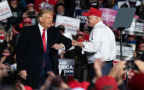 US congressman Mike Kelly bumps arms with President Donald Trump during a campaign rally at the Erie International Airport on Wednesday, 21 October, 2020, Pennsylvania.