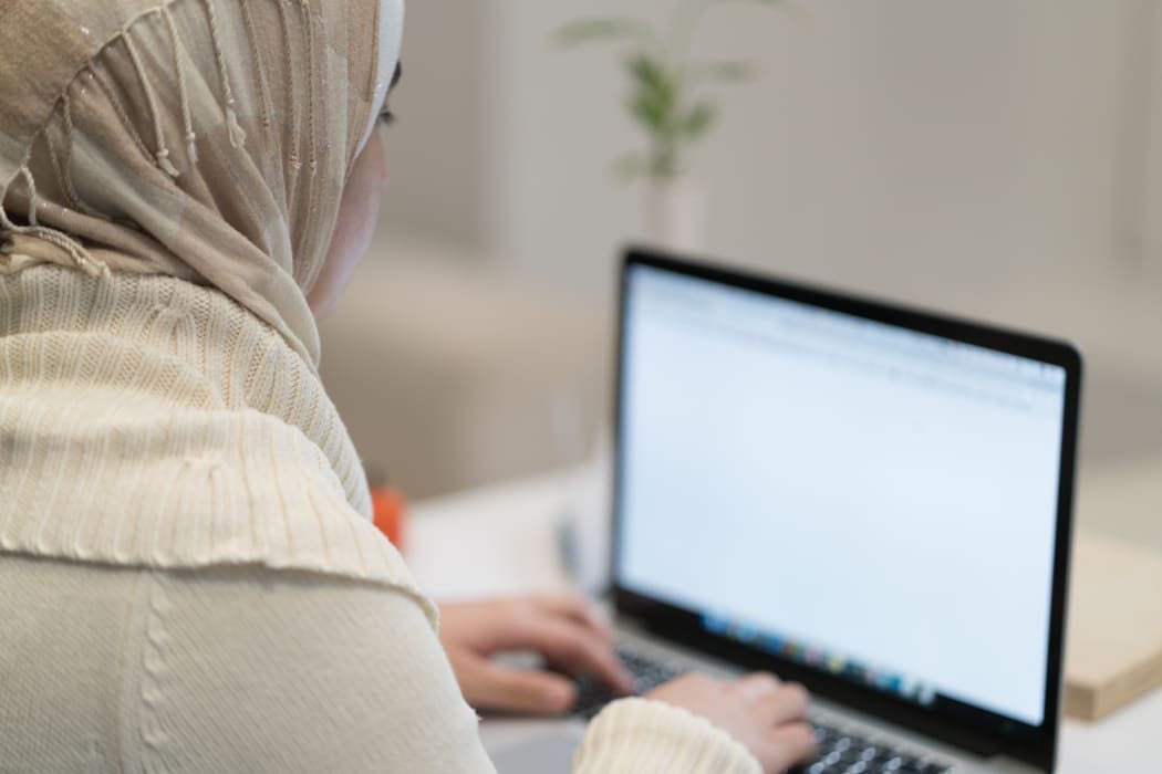 Muslim woman working/writing on laptop/typing.