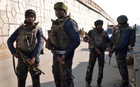 Indian security personnel stand alert on a road leading to an airforce base in Pathankot