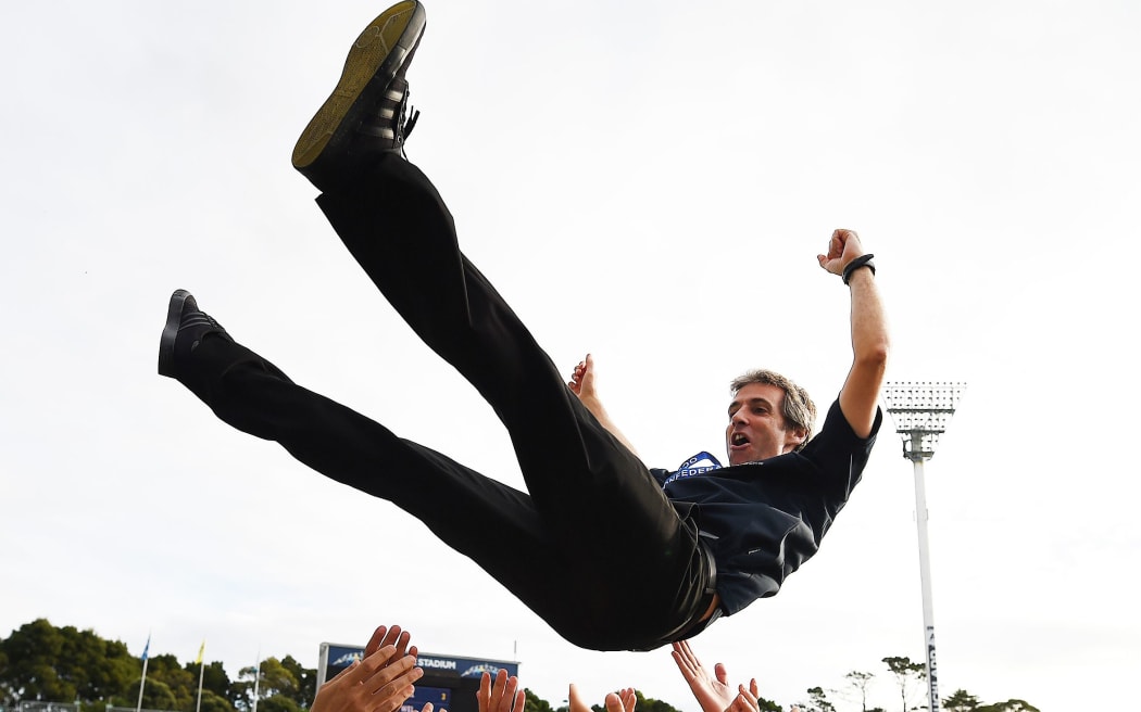 Auckland City coach Ramon Tribulietx is thrown skyward by in celebration.