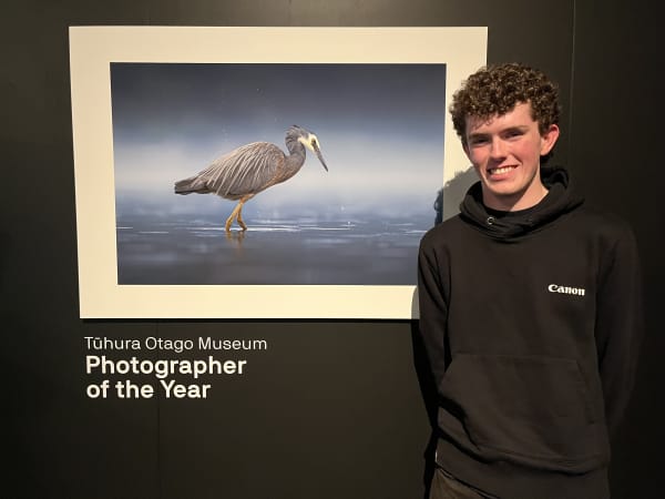 Sam McGee standing by his winning photo - Water Wings - of a white-faced heron.