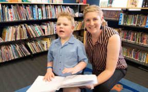 Paddy Wallace with his mum Kristy, he enjoys reading tactile books in Braille in the school library.