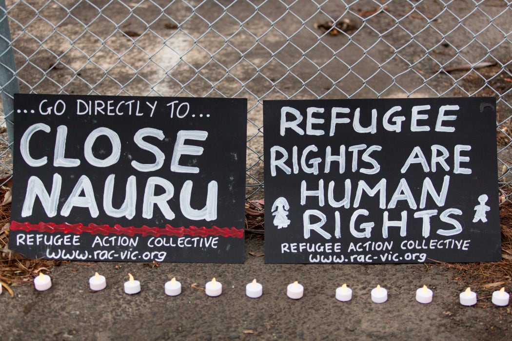 Two banners and candles at the gates of a refugee detention centre during a candlelight vigil. Asanka Brendon Ratnayake / Anadolu Agency
