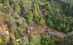A drone image captures the massive slip at Helena Bay Hill in Northland, cutting off Ōakura Bay.