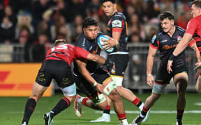 Wallace Sititi of the Chiefs is tackled by Braydon Ennor of the Crusaders.
