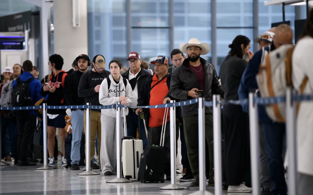 People wait in a security checkpoint line at George Bush Intercontinental Airport in Houston, Texas, on 4 November, 2025.