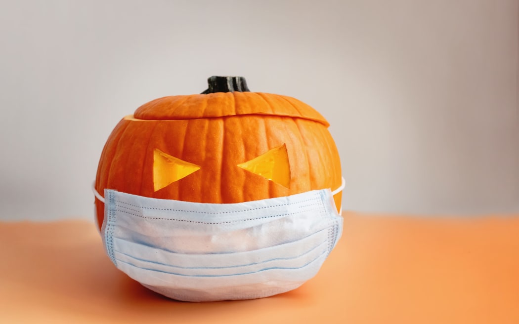 Orange pumpkin in a protective medical mask, Halloween during covid-19 pandemic times. New normal, year 2020 concept