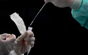 A health worker puts a swab into a tube after collecting a sample for Covid-19 coronavirus testing in Gombak on the outskirts of Kuala Lumpur on April 22, 2020.
