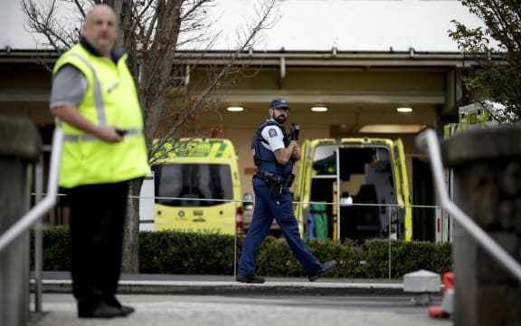 Law enforcement members stand guard at Christchurch Hospital, which is under lockdown, after a mass shootings at two mosques in Christchurch, New Zealand, Saturday, March 16, 2019. (AP Photo/Mark Baker)