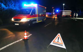 Rescuers gather on a road near the train line near Wuerzburg after the man who attacked train passengers with an axe was killed by German police.
