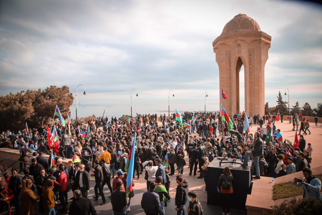 Azerbaijani people visit Alley of Martyrs, a cemetery and memorial dedicated to those killed by Soviet troops during the 1990 Black January, as they gather to celebrate the deal reached to halt fighting over the Nagorno-Karabakh region on November 10, 2020.