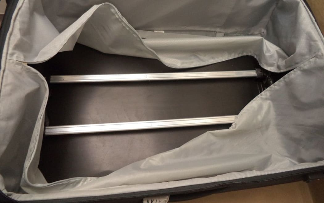 When Customs officers examined the  Samsonite suitcase, they found cocaine concealed behind the plastic backing of the suitcase.