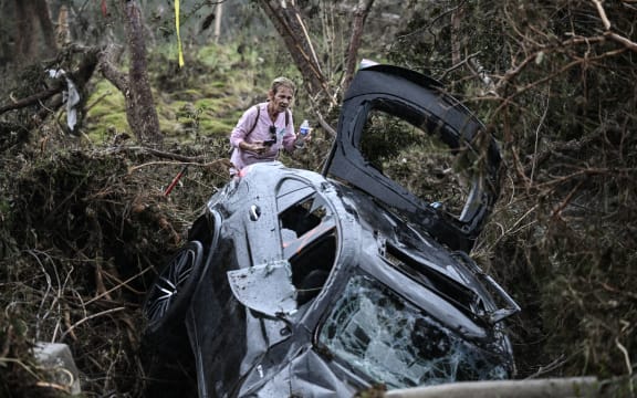 A volunteer looks for missing people, following severe flash flooding that occured during the July 4 holiday weekend, in Hunt, Texas, on July 6, 2025. Rescuers in Texas raced against time Sunday to find dozens of missing people, including children, swept away by flash floods that killed at least 59, as forecasters warned of new deluges. Local Texans joined forces with disaster officials to search through the night for the missing, including 27 girls from a riverside Christian summer camp. Texas Governor Greg Abbott said Camp Mystic on the banks of the Guadalupe River, where some 750 girls had been staying when the floodwaters hit, had been "horrendously ravaged in ways unlike I've seen in any natural disaster." (Photo by RONALDO SCHEMIDT / AFP)