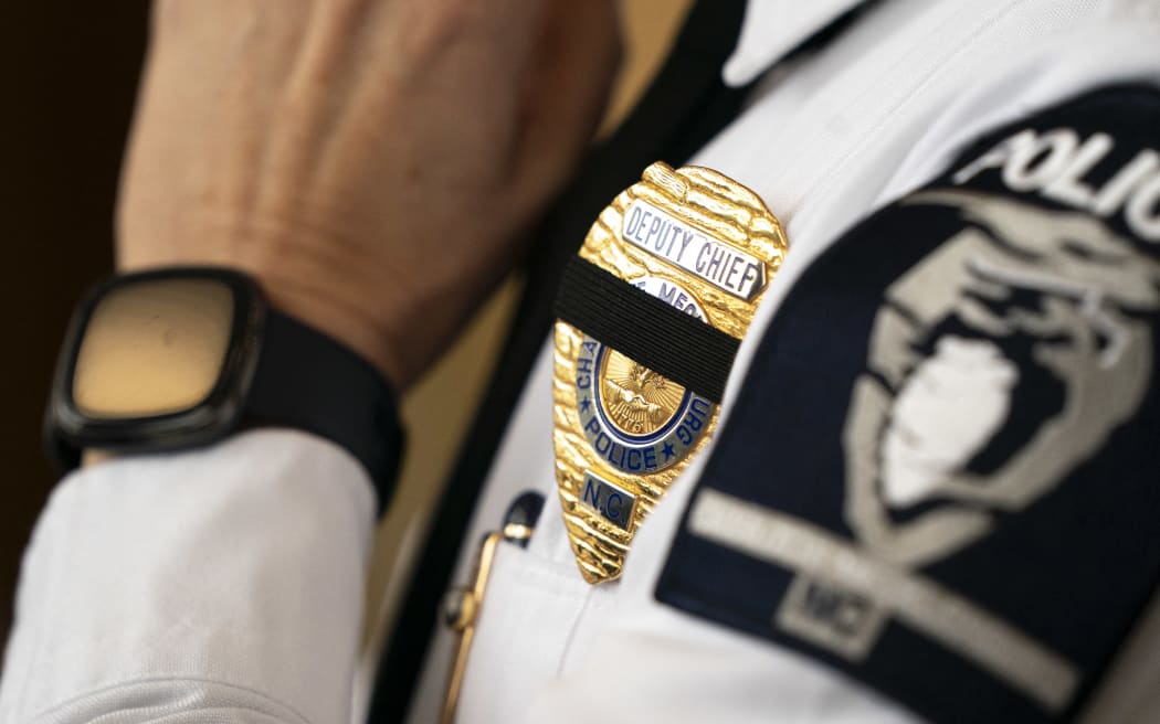 CHARLOTTE, NORTH CAROLINA - APRIL 30: A police officer wears a badge in memory of officers shot and killed the day before, following a press conference on April 30, 2024 in Charlotte, North Carolina. Four members of law enforcement were shot and killed the previous day while serving a warrant at a residence in Charlotte. Police fatally shot the suspect, identified as 39-year-old Terry Clark Hughes Jr. who was wanted for possession of a firearm by a felon and two counts of felony flee to elude out of Lincoln County, North Carolina.   Sean Rayford/Getty Images/AFP (Photo by Sean Rayford / GETTY IMAGES NORTH AMERICA / Getty Images via AFP)