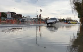 A car travels through floodwater on Innes Rd, Christchurch after a blown watermain.