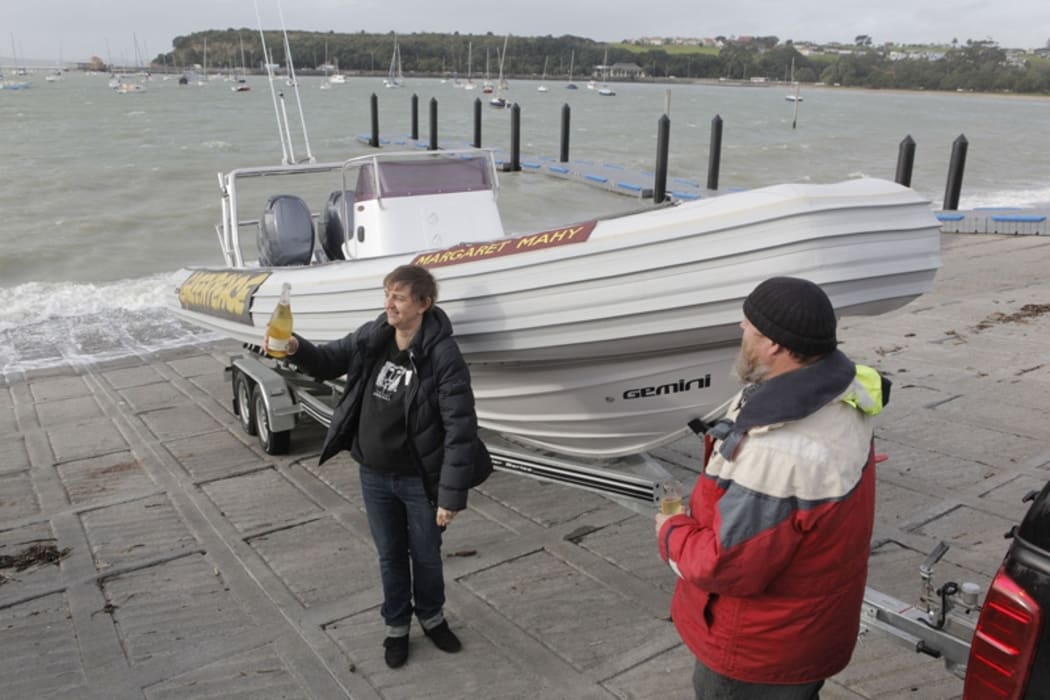 Daughter Bridget Mahy and Greenpeace's Logan Petley toast the boat on Thursday.