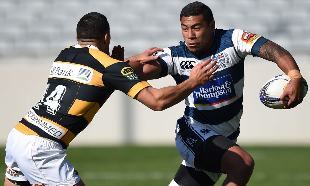 The Auckland All Black Charles Piutau  fends Taranaki's Kurt Baker.