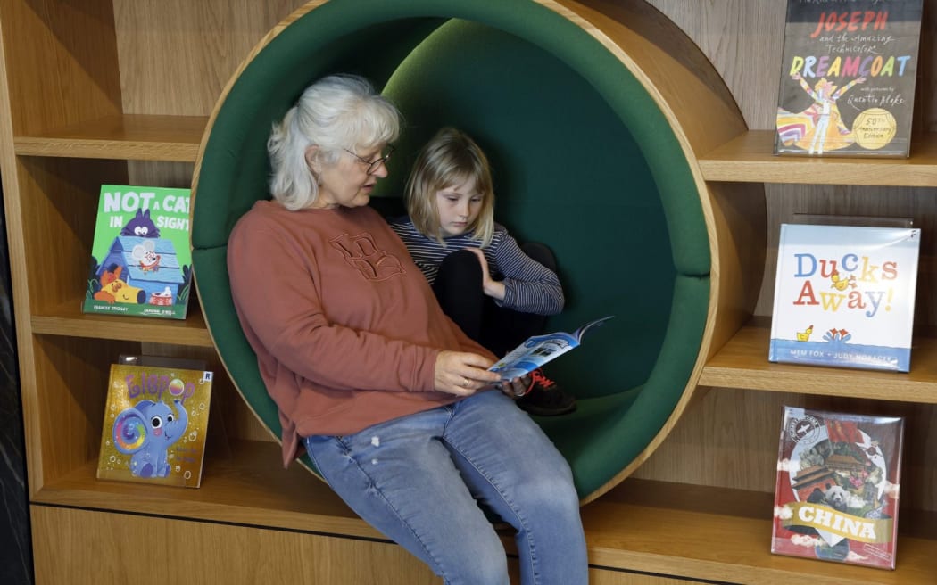 Liz Nash, left, and Mabel McMurtrie, 7, test out the new children’s area in the library