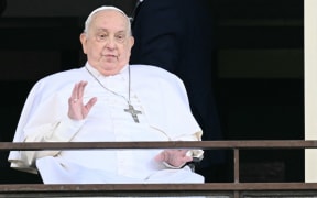 Pope Francis waves from a window of the Gemelli hospital before being discharged following a five weeks hospitalization for pneumonia, in Rome on March 23, 2025. Pope Francis is to leave hospital todayand return to his residence in the Vatican, where he is to spend "at least two months" recovering, one of his doctors announced during a press conference on March 22, 2025. (Photo by Filippo MONTEFORTE / AFP)