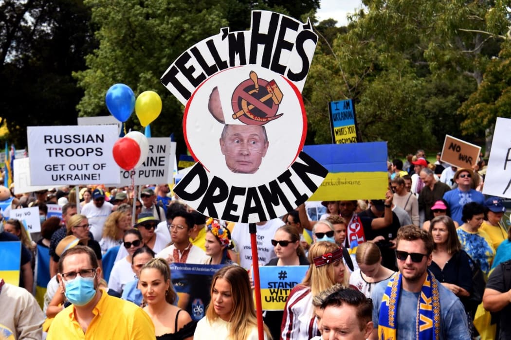 People hold up placards during a march to protest against the Russian invasion of Ukraine, in Melbourne on February 27, 2022.