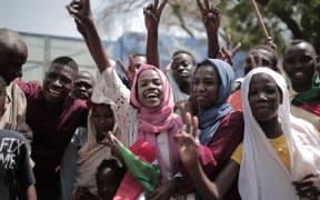 Sudanese men and women celebrate outside the Friendship Hall in the capital Khartoum where generals and protest leaders signed a historic transitional constitution